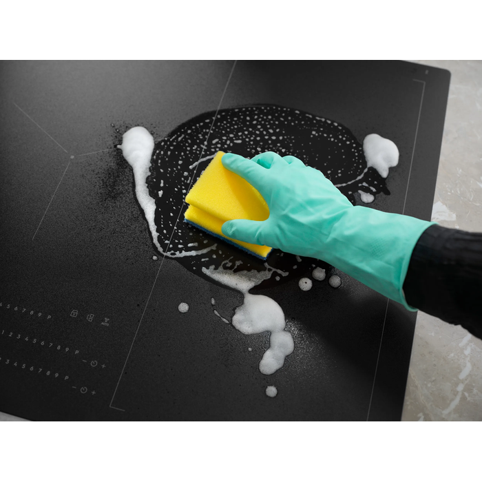 Hob Cleaner being applied with foam and sponge, highlighting its easy-to-clean feature.