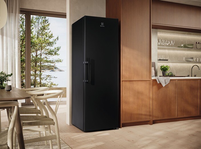 A black refrigerator is placed in a modern kitchen from Electrolux.
