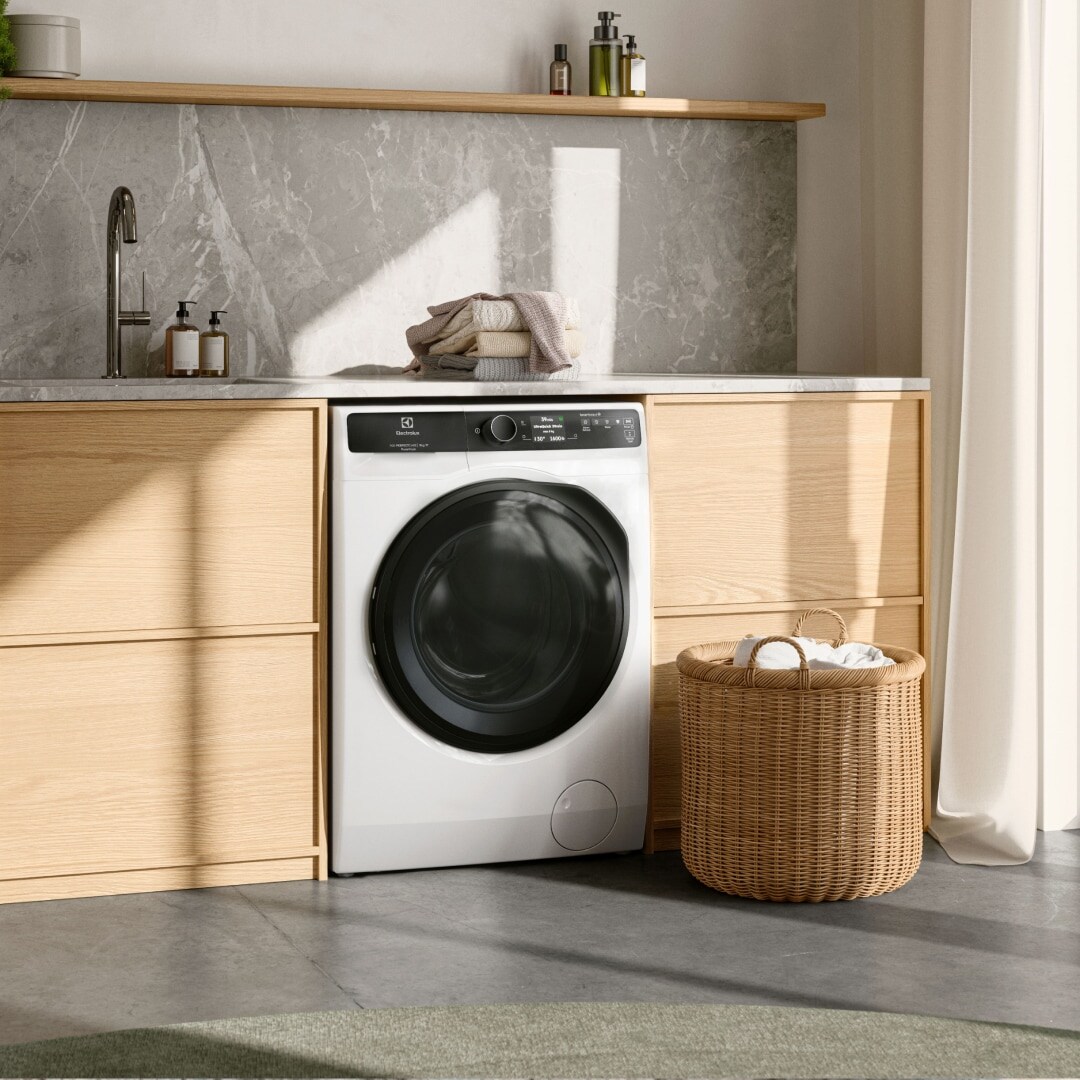 Bright laundry room with a washing machine under a bench.